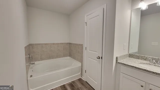 a bathroom with a granite countertop bathtub shower and vanity
