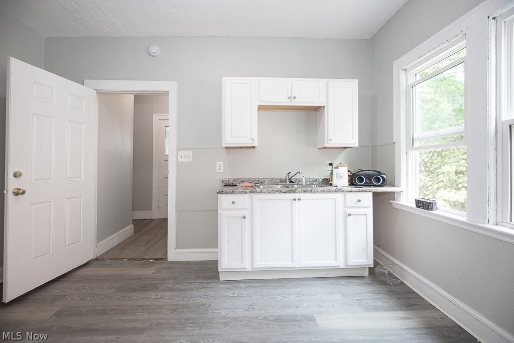 1000 Eddy Road Cleveland, OH 44108 - Photo 10 of 38 Kitchen featuring white cabinets, light wood-type flooring, and light stone countertops