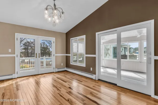 a kitchen with stainless steel appliances granite countertop a table chairs and a wooden floor