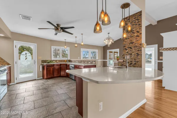 a kitchen with stainless steel appliances granite countertop a stove microwave refrigerator and sink