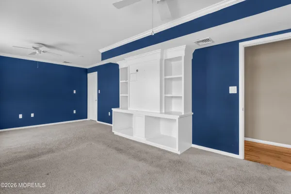 a view of an empty room with closet and entryway