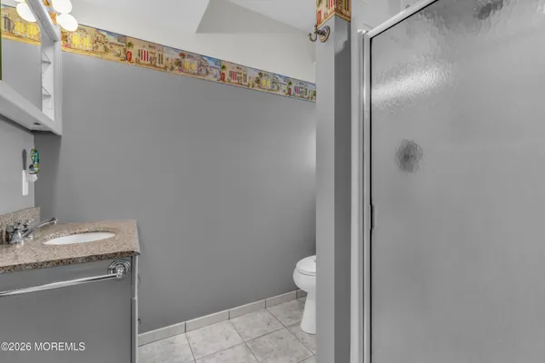 a bathroom with a granite countertop sink toilet and a mirror