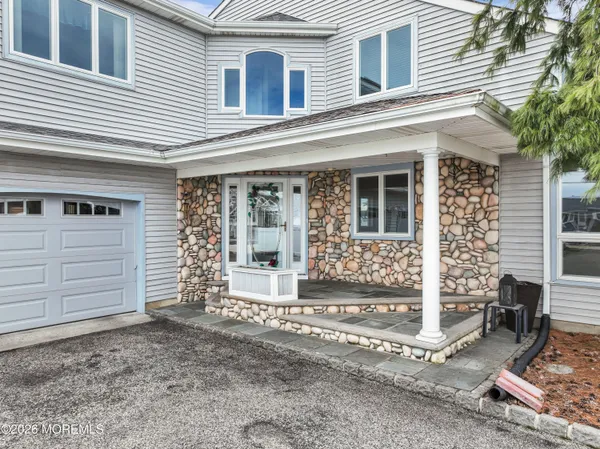a view of an empty room with wooden floor and a chandelier fan