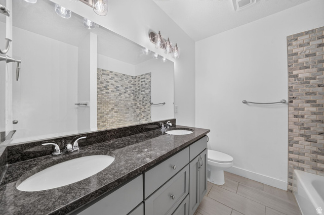 1002 West Temple Rim Lane Payson, UT 84651 - Photo 51 of 68 Dual vanity with a dark speckled countertop, undermount sinks, and chrome faucets