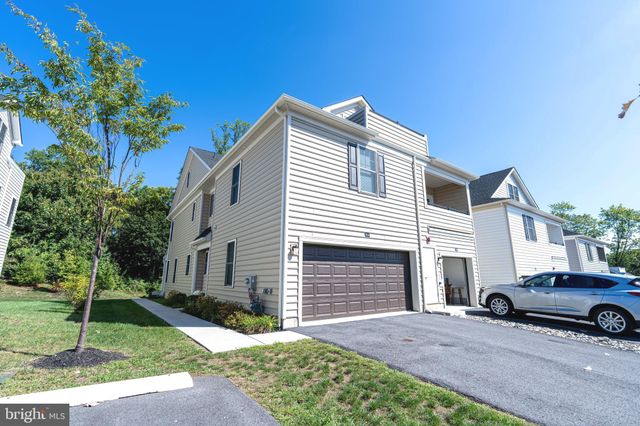 a white house that has a small yard and parking space