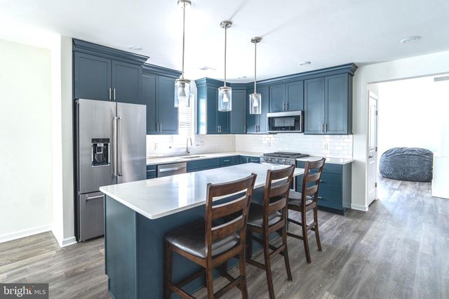 a kitchen with a table chairs refrigerator and cabinets