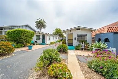 a front view of a house with a yard and potted plants