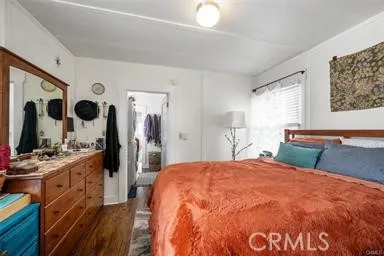 a bedroom with a large bed and a flat tv screen on dresser