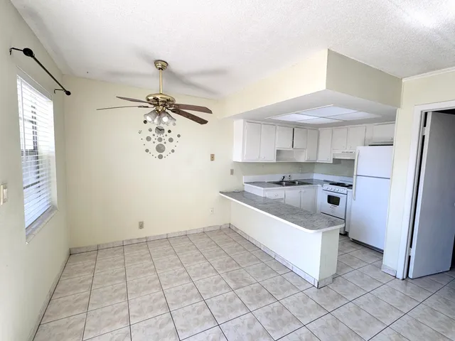 a kitchen with white cabinets and white appliances