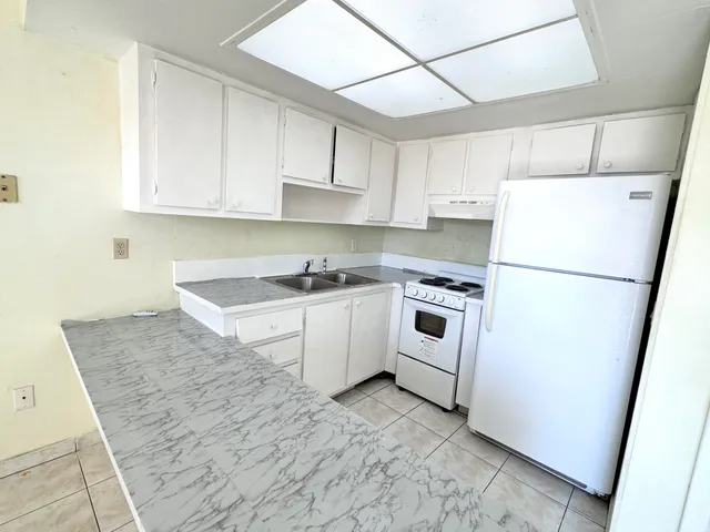 a room with white cabinets and appliances