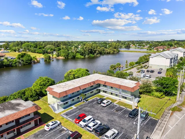 an aerial view of residential houses with outdoor space and lake view