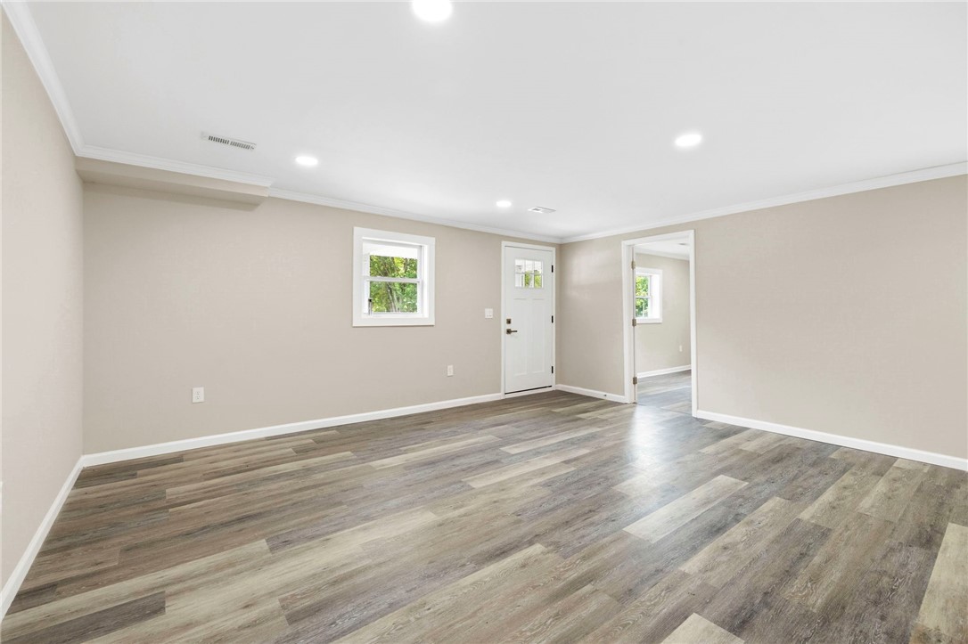 418 Old River Road Pelzer, SC 29669 - Photo 5 of 29 A well-lit interior space with sleek wood flooring, a convenient entrance, and clear sightlines to an adjacent room.