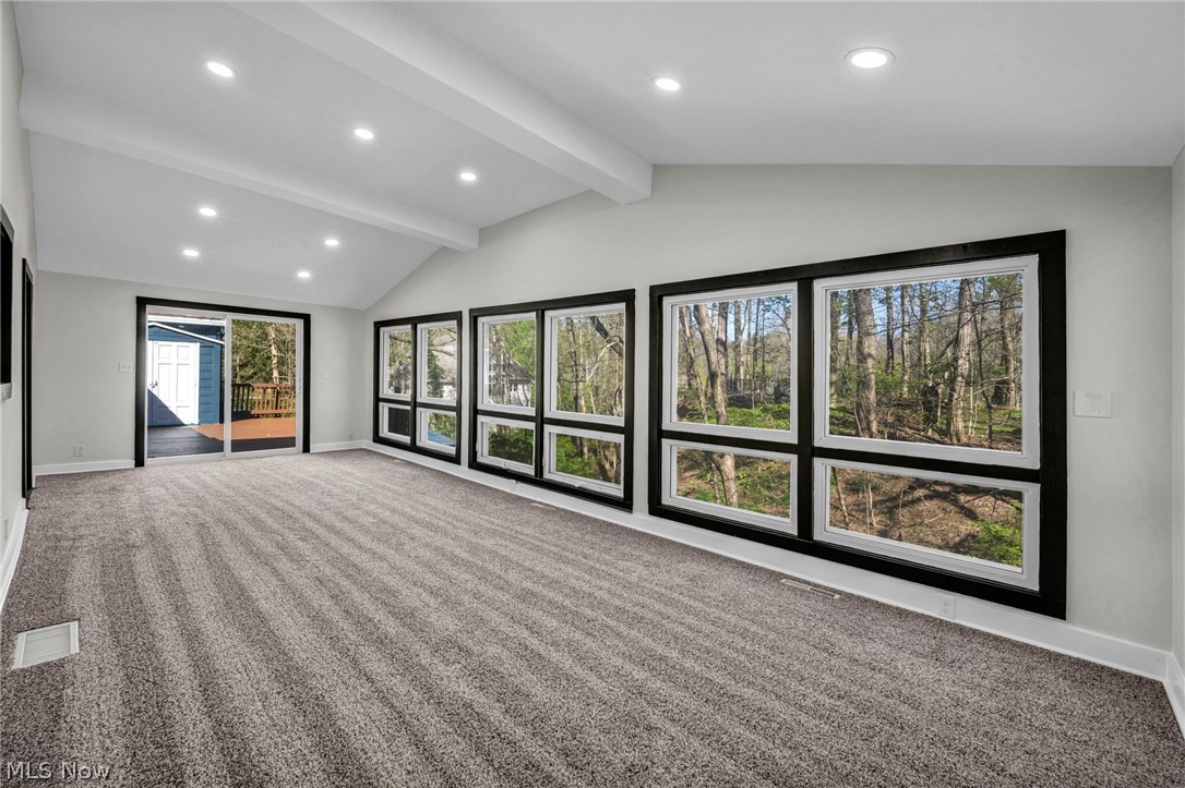 7339 River Road Olmsted Falls, OH 44138 - Photo 19 of 45 Spacious room featuring vaulted ceilings with exposed beams, recessed lighting, and expansive windows with black trim