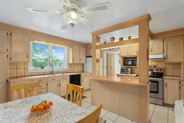a kitchen with stainless steel appliances granite countertop a stove a sink dishwasher and a refrigerator with wooden floor