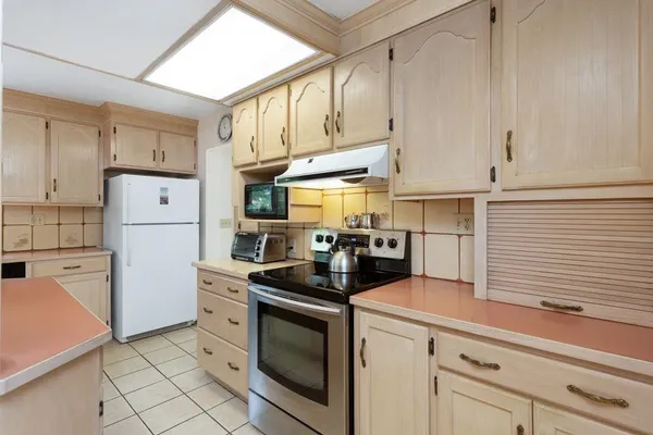 a kitchen with cabinets stainless steel appliances and a window