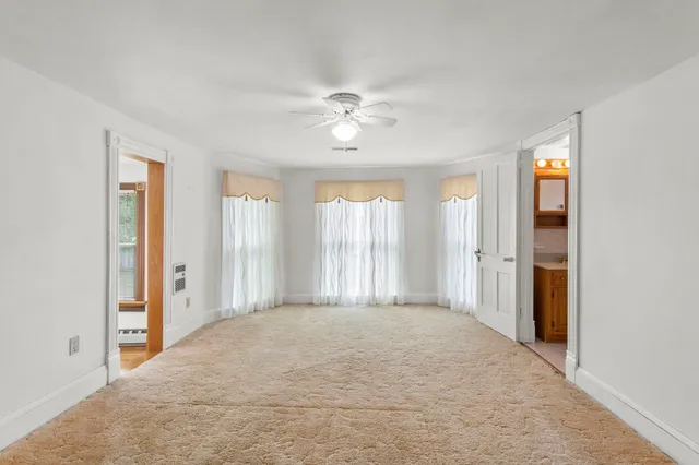 a view of a bedroom with a ceiling fan and a window