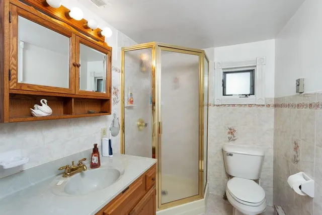 a bathroom with a sink a toilet and shower