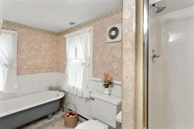 a bathroom with a tub a sink and a large mirror