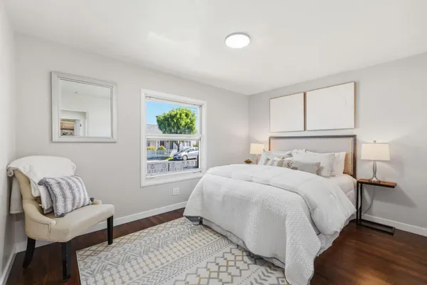 a bedroom with a bed mirror and window