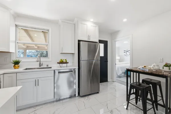 a kitchen with stainless steel appliances granite countertop a sink a stove and white cabinets