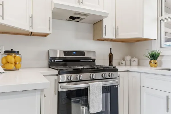 a kitchen with stainless steel appliances granite countertop a refrigerator and a stove top oven