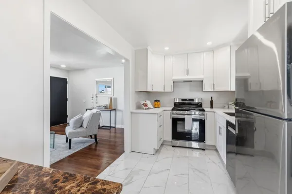 a kitchen with stainless steel appliances granite countertop a refrigerator and a stove