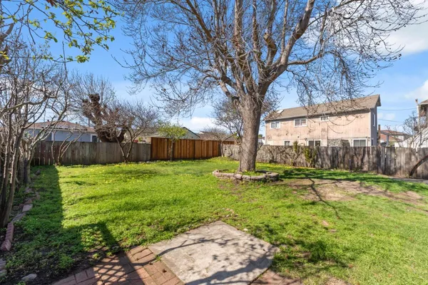 a view of a house with backyard and a tree