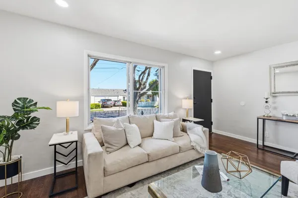 a living room with furniture and wooden floor