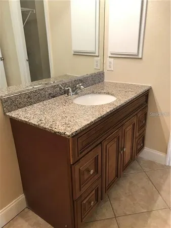 a bathroom with a granite countertop sink and a mirror