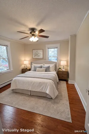 a bedroom with a large bed chandelier and a window