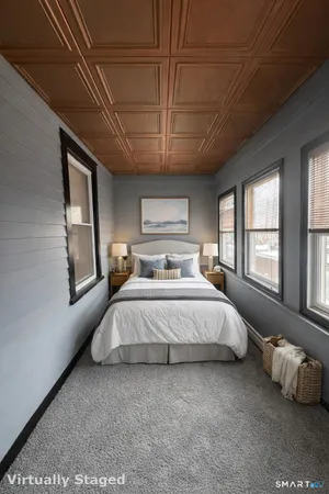 a spacious bedroom with a bed couch and window