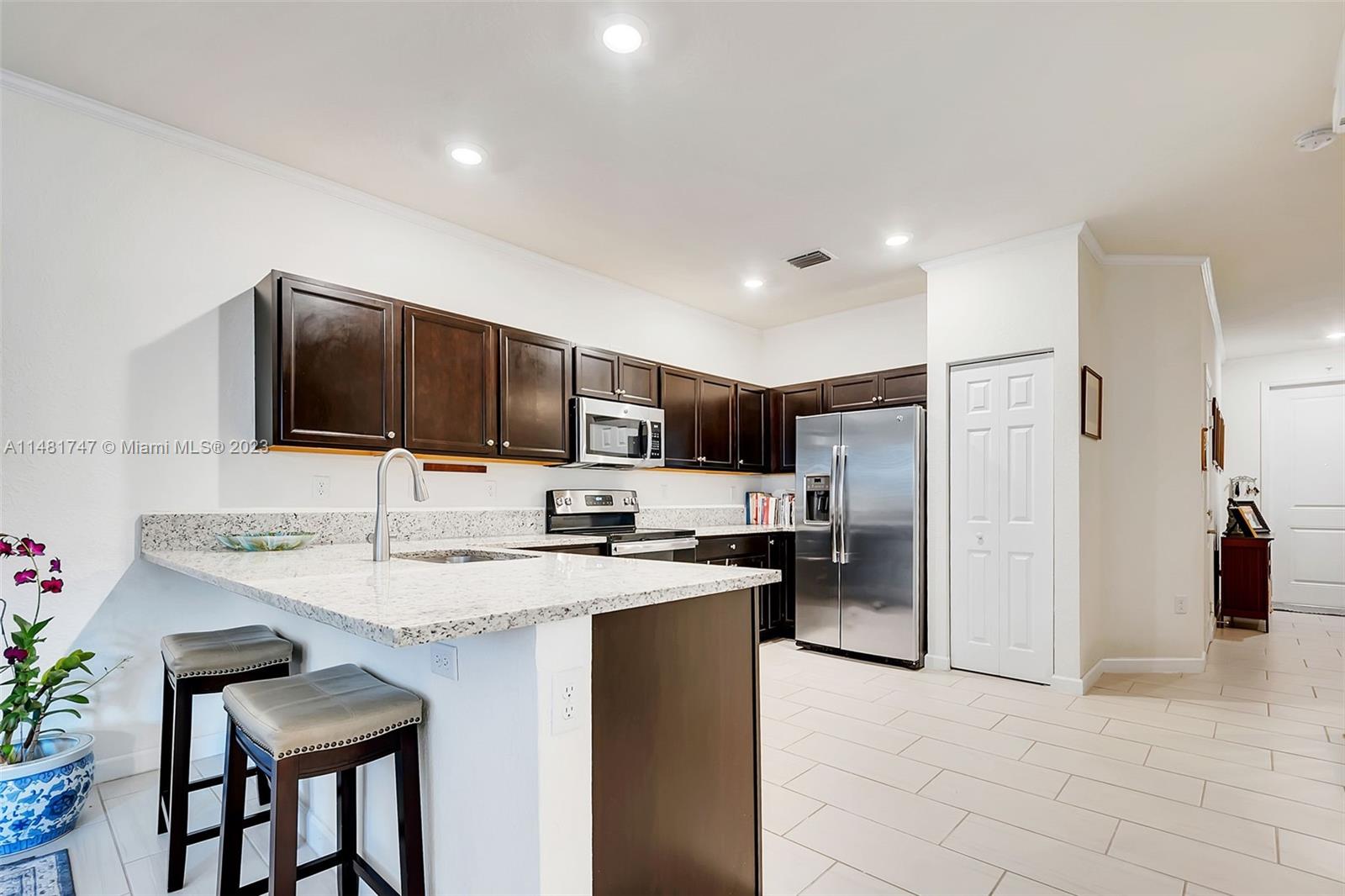 15073 Southwest 119TH Lane Miami, FL 33196 - Photo 14 of 25 a kitchen with stainless steel appliances granite countertop a sink refrigerator and cabinets