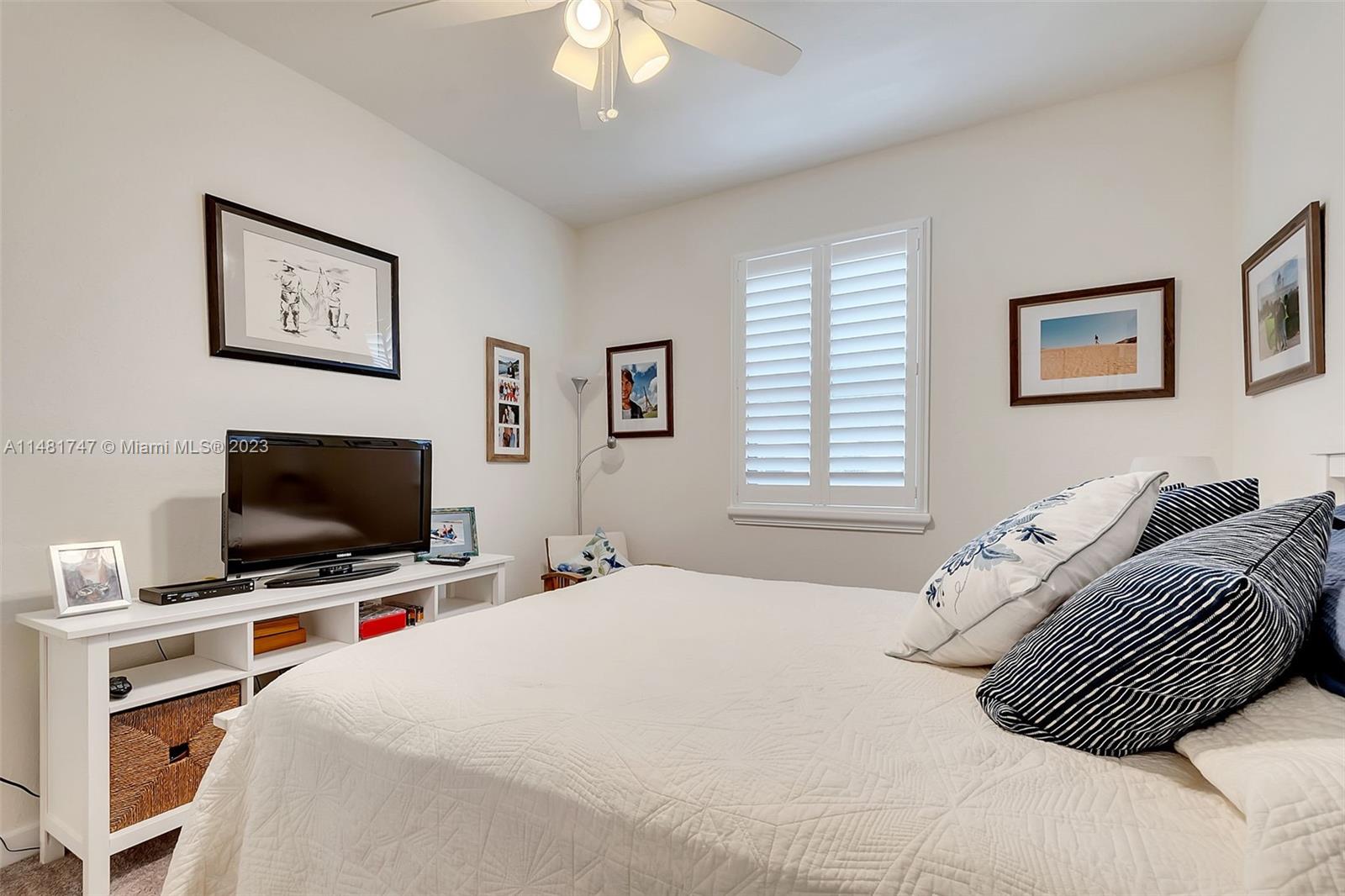 15073 Southwest 119TH Lane Miami, FL 33196 - Photo 22 of 25 a bedroom with a bed and a flat screen tv