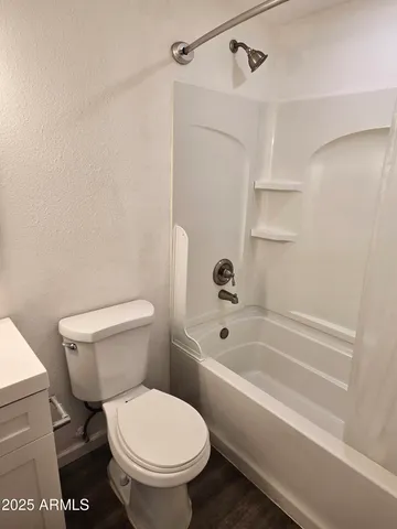 a white toilet and tub sitting next to a bathroom sink
