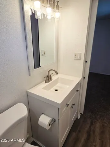 a bathroom with a sink toilet and mirror