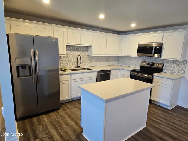 a kitchen with stainless steel appliances a refrigerator sink and microwave