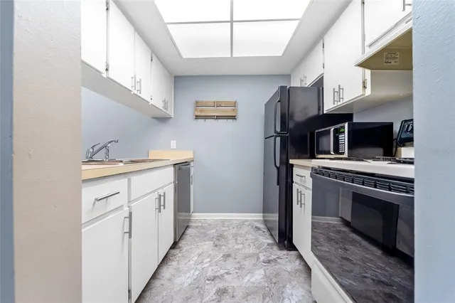 a kitchen with stainless steel appliances granite countertop a stove a refrigerator and a sink