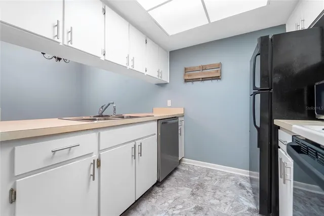 a kitchen with stainless steel appliances a sink a refrigerator and cabinets
