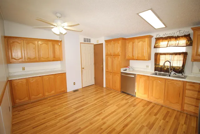 a view of a kitchen with wooden floor and a sink