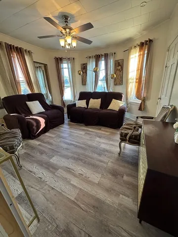 a living room with furniture ceiling fan and a window