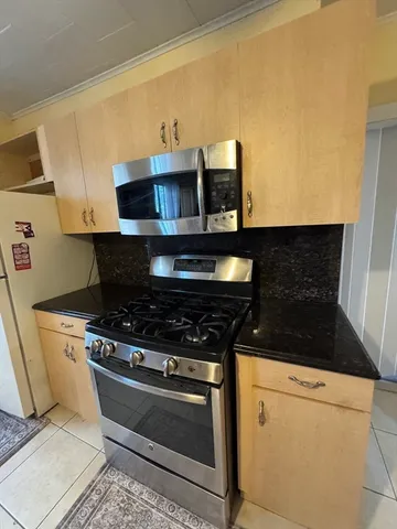 a kitchen with stainless steel appliances granite countertop a stove and a microwave with granite countertops