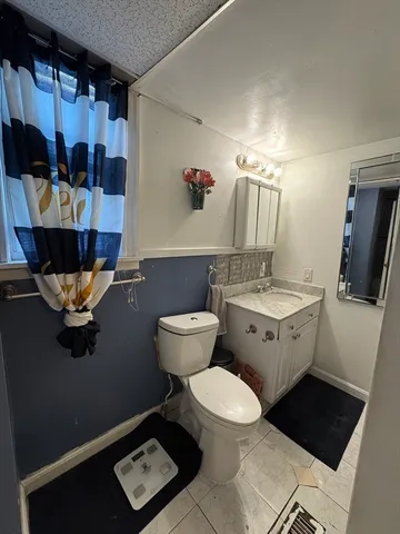 a bathroom with a toilet sink and mirror