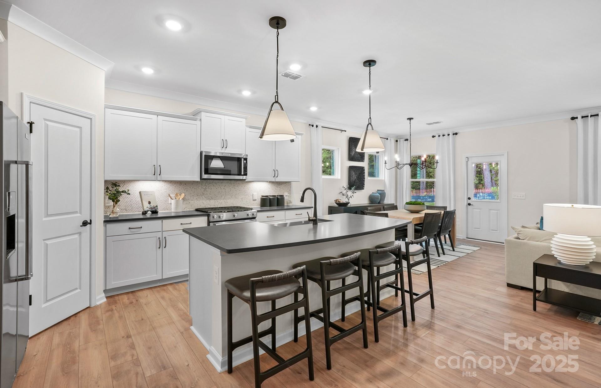 12016 Rails Court, Unit 516 Charlotte, NC 28278 - Photo 11 of 39 a kitchen with granite countertop stainless steel appliances a stove a sink a oven a dining table and chairs
