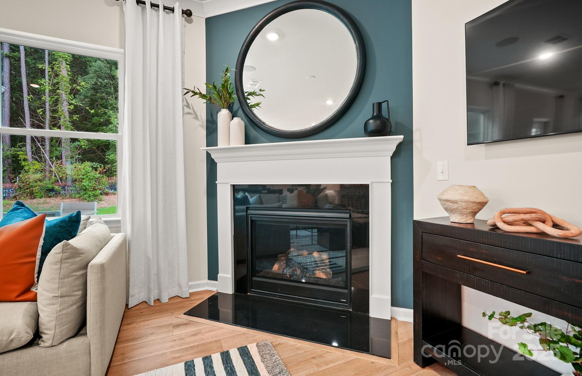 12016 Rails Court, Unit 516 Charlotte, NC 28278 - Photo 16 of 39 a living room with furniture a mirror and a fireplace