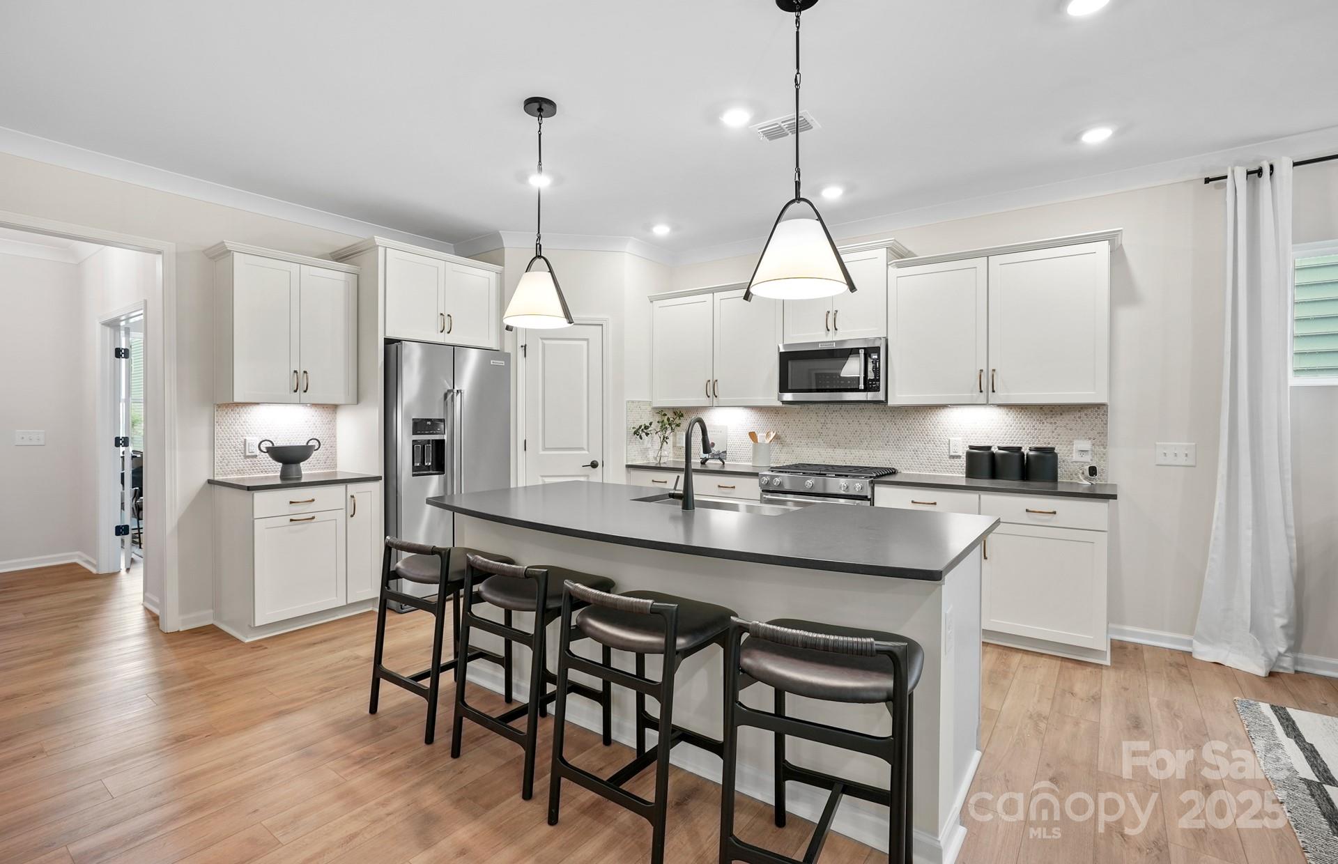 12016 Rails Court, Unit 516 Charlotte, NC 28278 - Photo 5 of 39 a kitchen with stainless steel appliances granite countertop a sink a stove a refrigerator and wooden floor