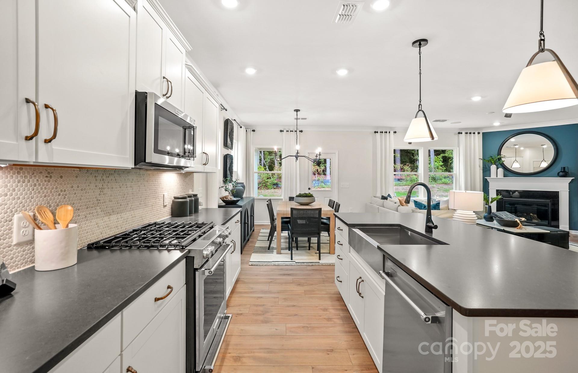 12016 Rails Court, Unit 516 Charlotte, NC 28278 - Photo 9 of 39 a kitchen with kitchen island granite countertop a sink a stove oven a counter top space and cabinets