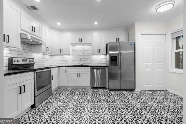 a kitchen with stainless steel appliances granite countertop a refrigerator sink and cabinets