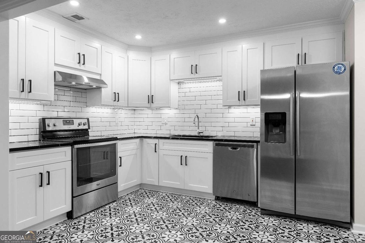 365 Winding River Drive Atlanta, GA 30350 - Photo 11 of 34 a kitchen with stainless steel appliances granite countertop a refrigerator a sink a stove a microwave and cabinets