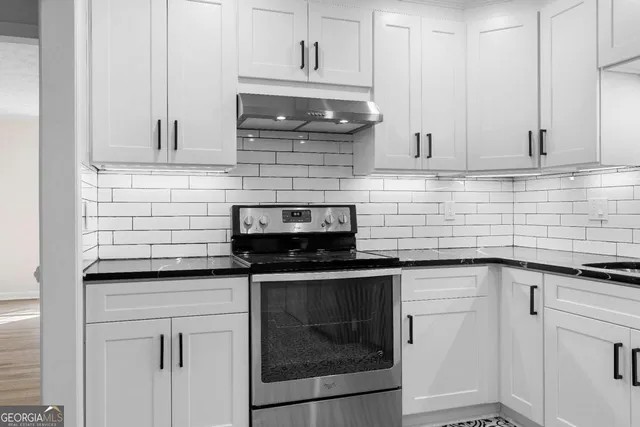 a kitchen with stainless steel appliances granite countertop a sink and cabinets