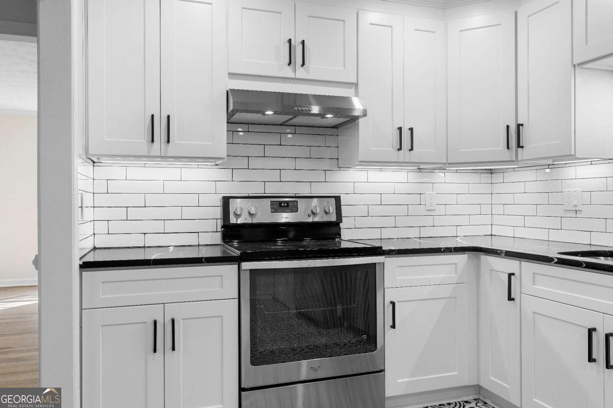 365 Winding River Drive Atlanta, GA 30350 - Photo 13 of 34 a kitchen with granite countertop white cabinets and stainless steel appliances